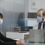 Physician having conversation with woman at checkup visit
