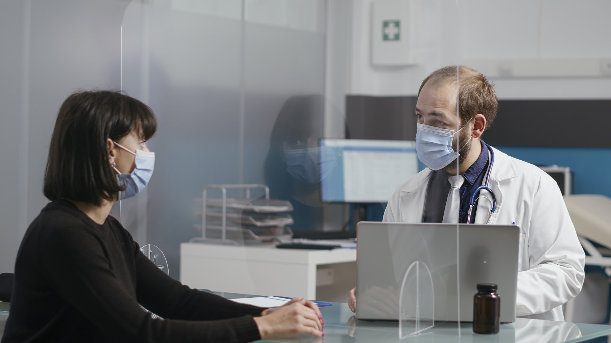 Physician having conversation with woman at checkup visit